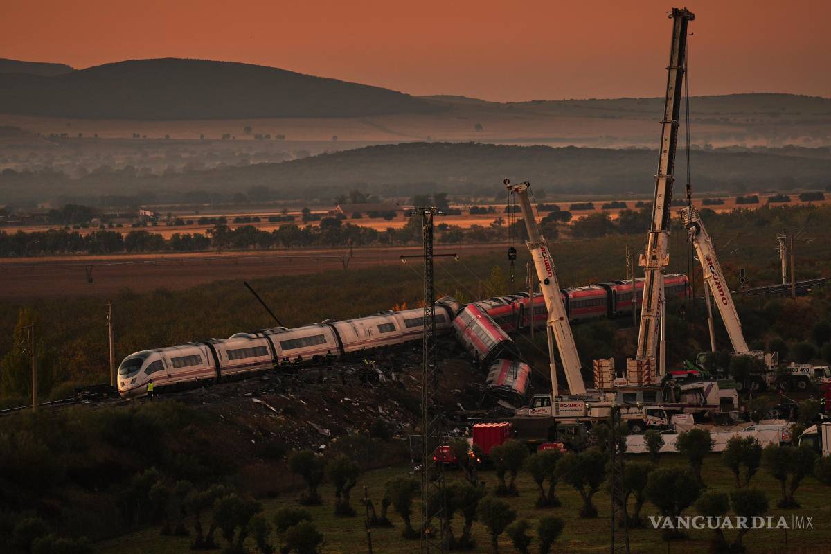 $!Grúas levantan vagones de tren mientras rescatistas buscan víctimas de una colisión entre dos trenes en Urda, España, el jueves 29 de octubre de 2026.