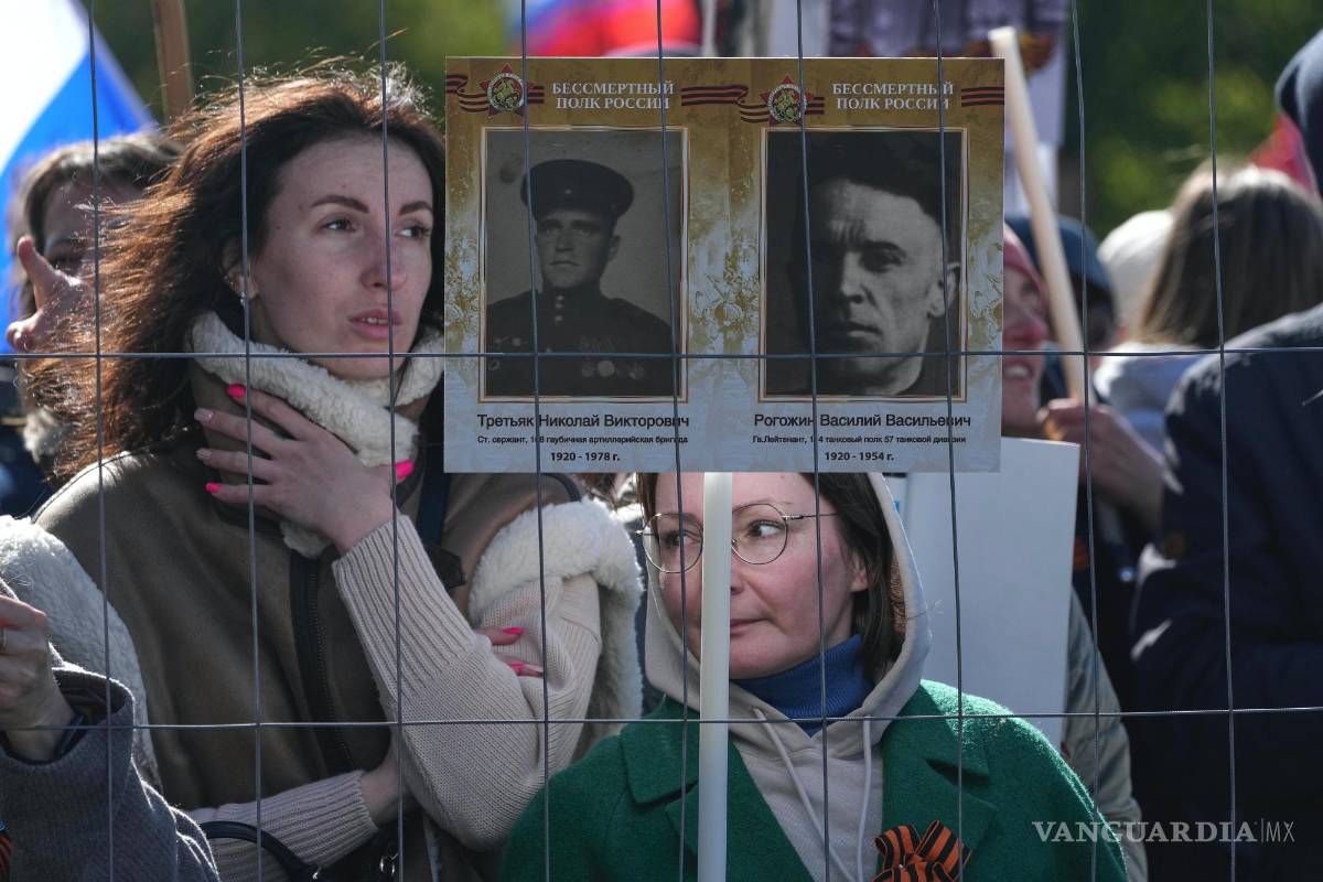 $!Personas con retratos de familiares que lucharon en la Segunda Guerra Mundial en la Plaza del Palacio en San Petersburgo, Rusia.