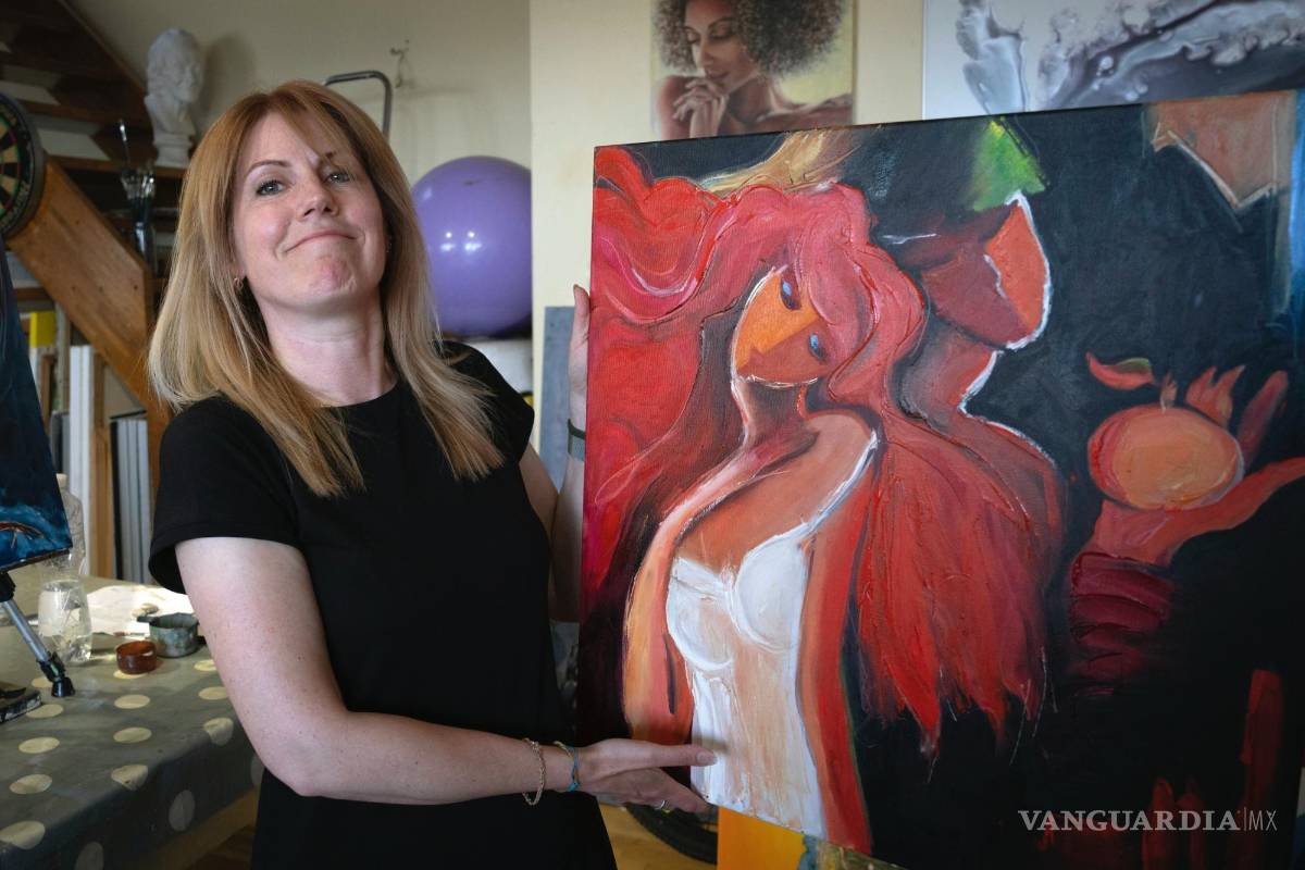 $!Vita Kahaniuk sostiene su pintura que creó para conmemorar a su esposo, un soldado que murió en una batalla con las tropas rusas en Kiev.