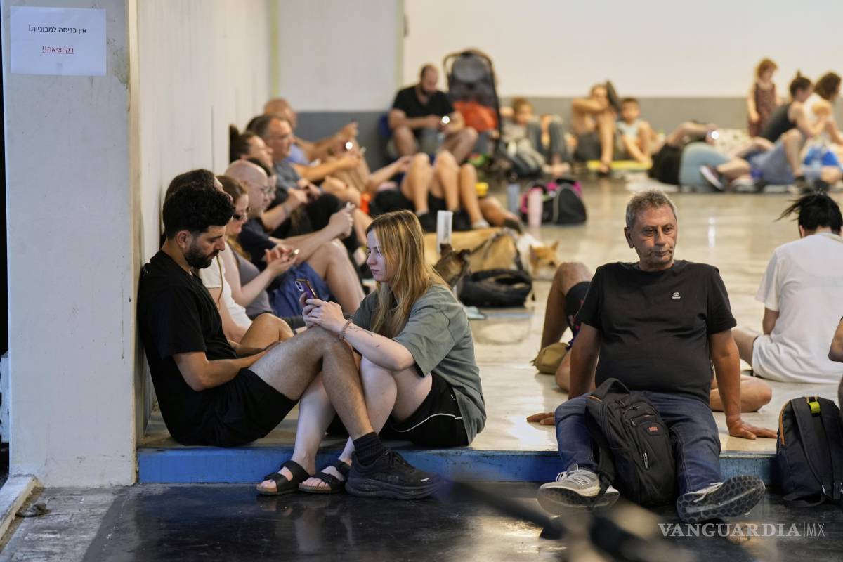 $!Israelíes se sientan en un refugio mientras las sirenas advierten de fuego inminente en Tel Aviv.