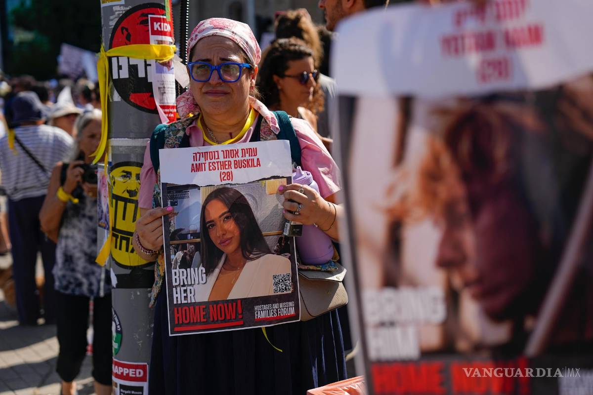 $!Residentes del kibutz Kfar Azza atacada por Hamás, sostienen fotografías de sus seres queridos, piden el regreso de más de 220 rehenes, en Tel Aviv, Israel.