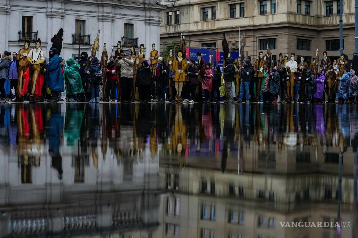 $!Personas muestran imágenes de sus familiares en una marcha para recordar la llamada Operación Colombo en Santiago, Chile, el 22 de julio de 2023.