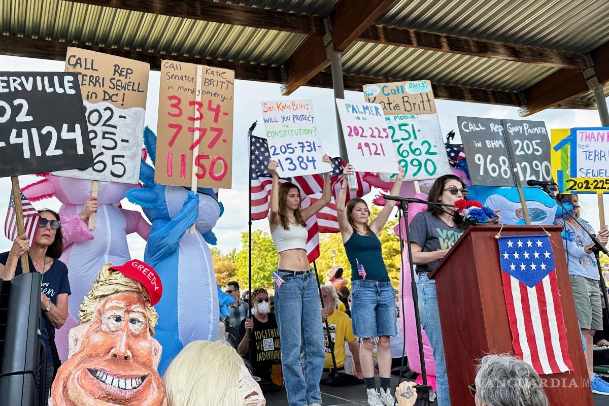 $!Becca Rothman y manifestantes con carteles con los números de teléfono de las oficinas de los representantes electos de Alabama durante la protesta “No Kings”.