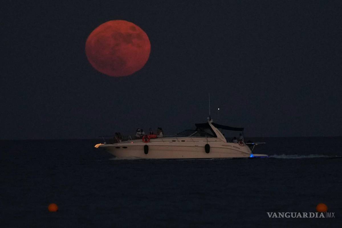 $!La luna llena se eleva sobre un barco en la ciudad mediterránea de Larnaca, en el sureste de Chipre, el 13 de julio de 2022.
