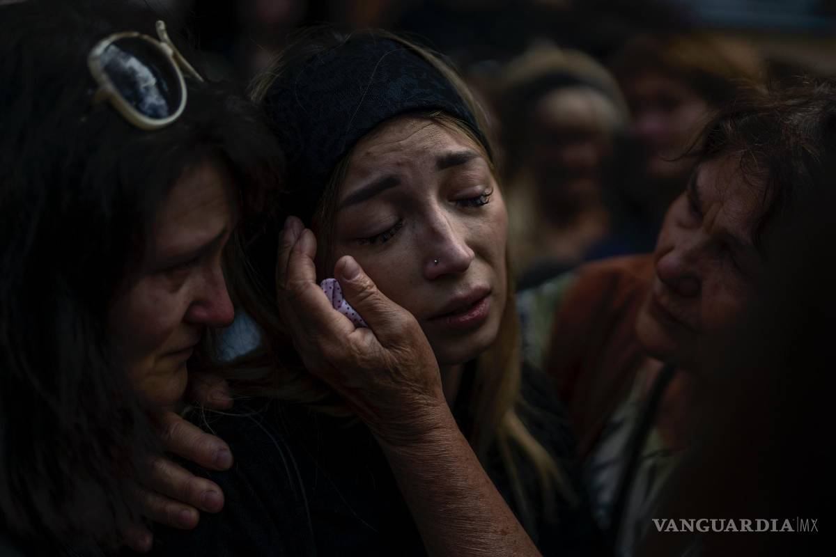 $!Anastasia Ohrimenko es consolada por sus familiares mientras llora junto al féretro de su esposo durante su funeal, en Bucha, Ucrania, el 31 de agosto de 2022.