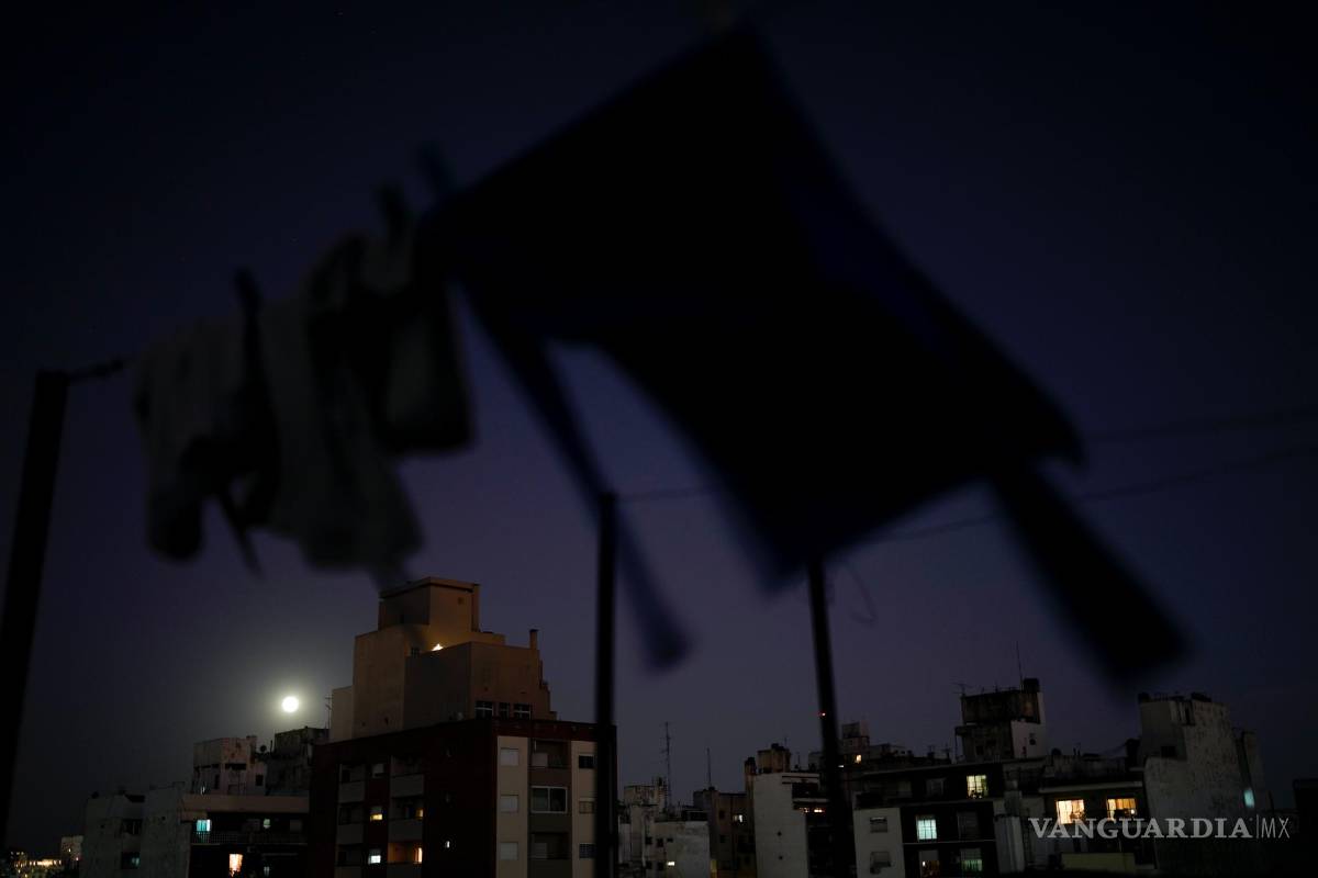 $!Ropa tendida para secarse en una terraza mientras la luna llena se eleva sobre Buenos Aires, Argentina, el miércoles 13 de julio de 2022.