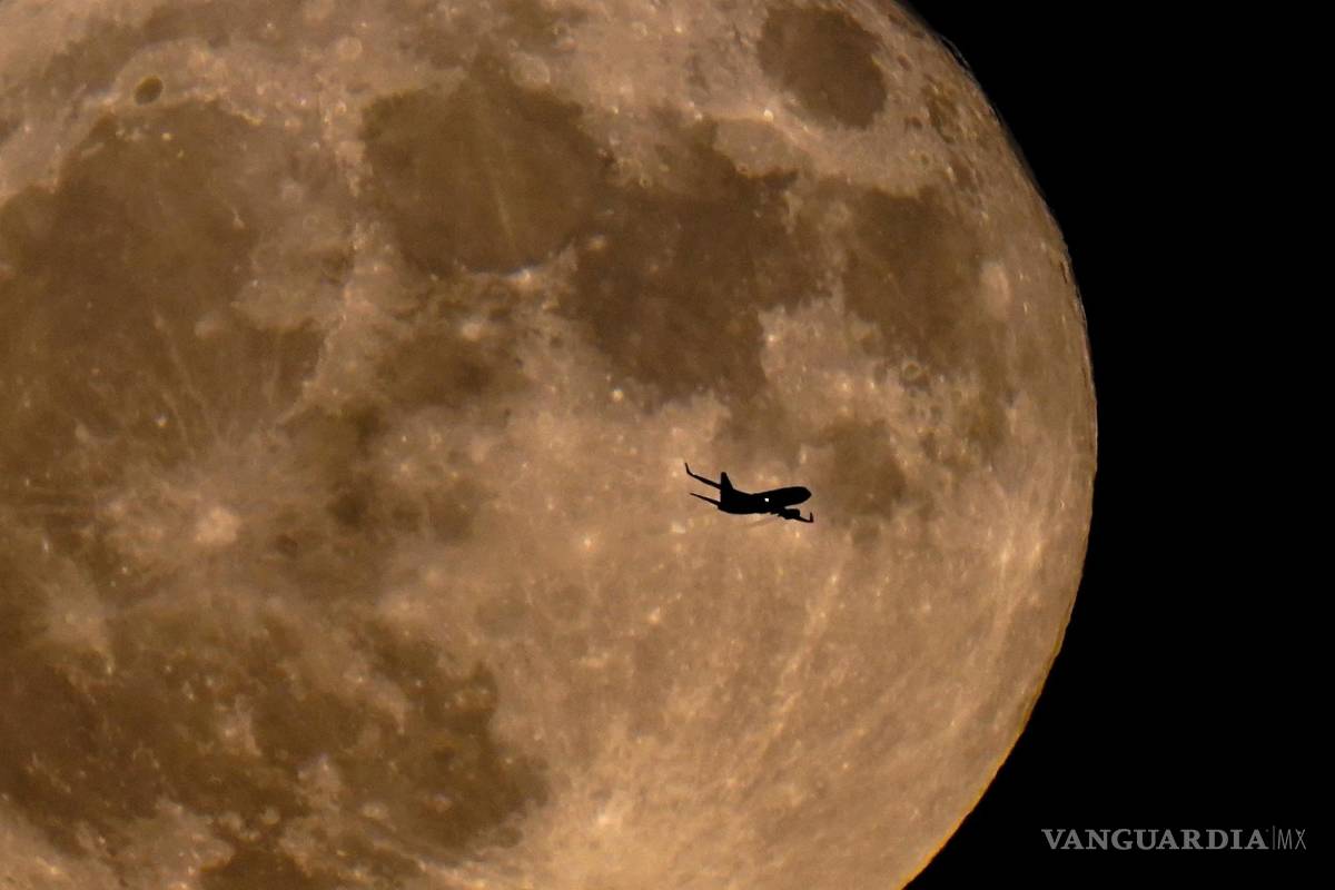 $!La silueta de un avión se recorta sobre la luna llena en Milwaukee, el 13 de julio de 2022.