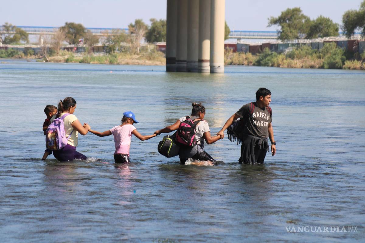 $!Una familia hace cadena para cruzar las aguas del río Bravo y entregarse a las autoridades de Estados Unidos.