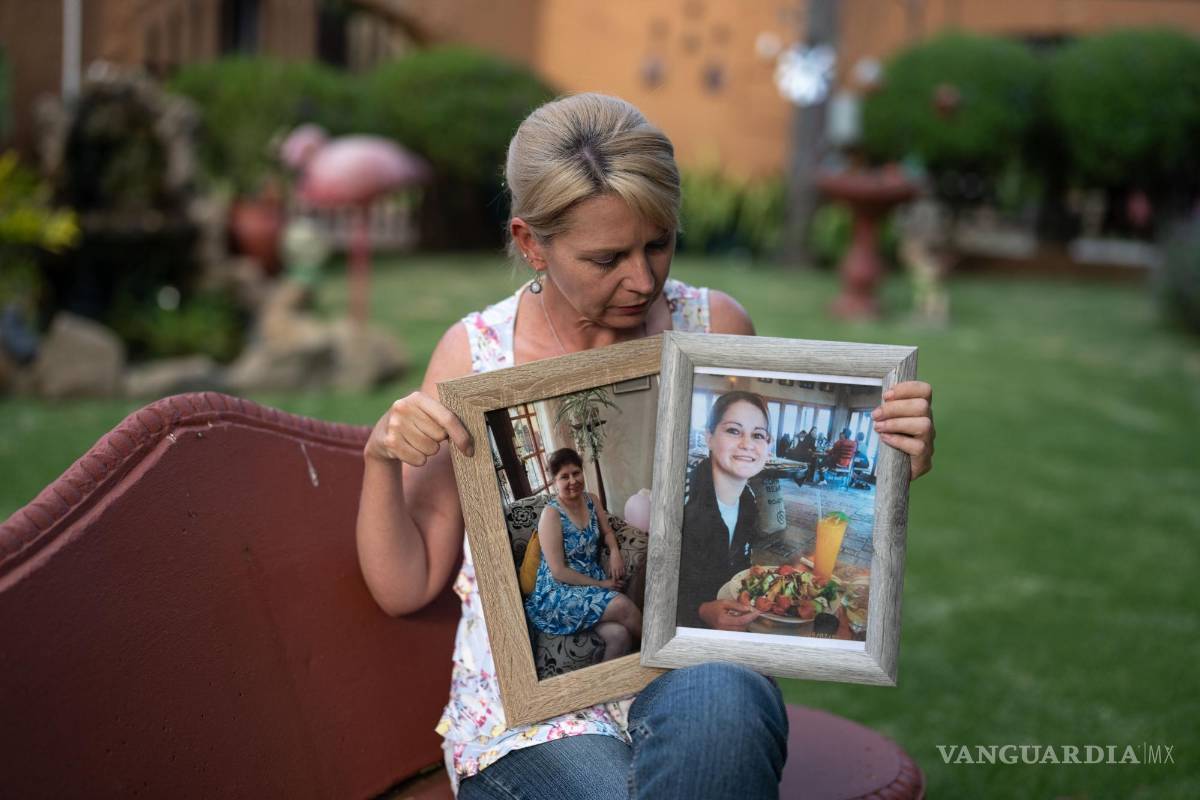 $!Belinda Nell con fotos de sus hermanas Lorryn y Jennifer, quienes murieron de fibrosis quística, en Johannesburgo.