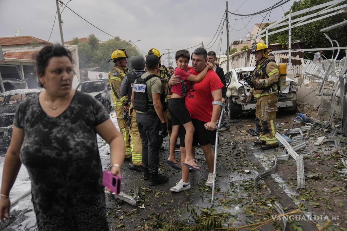 $!Israelíes evacuan una zona alcanzada por un proyectil disparado desde la Franja de Gaza, en Ashkelon, en el sur de Israel, el 9 de octubre de 2023.