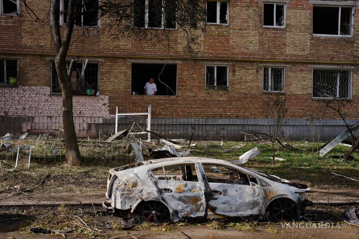 $!Un hombre se asoma desde su apartamento en un edificio residencial dañado tras un ataque ruso con misiles y drones en Kiev, Ucrania.