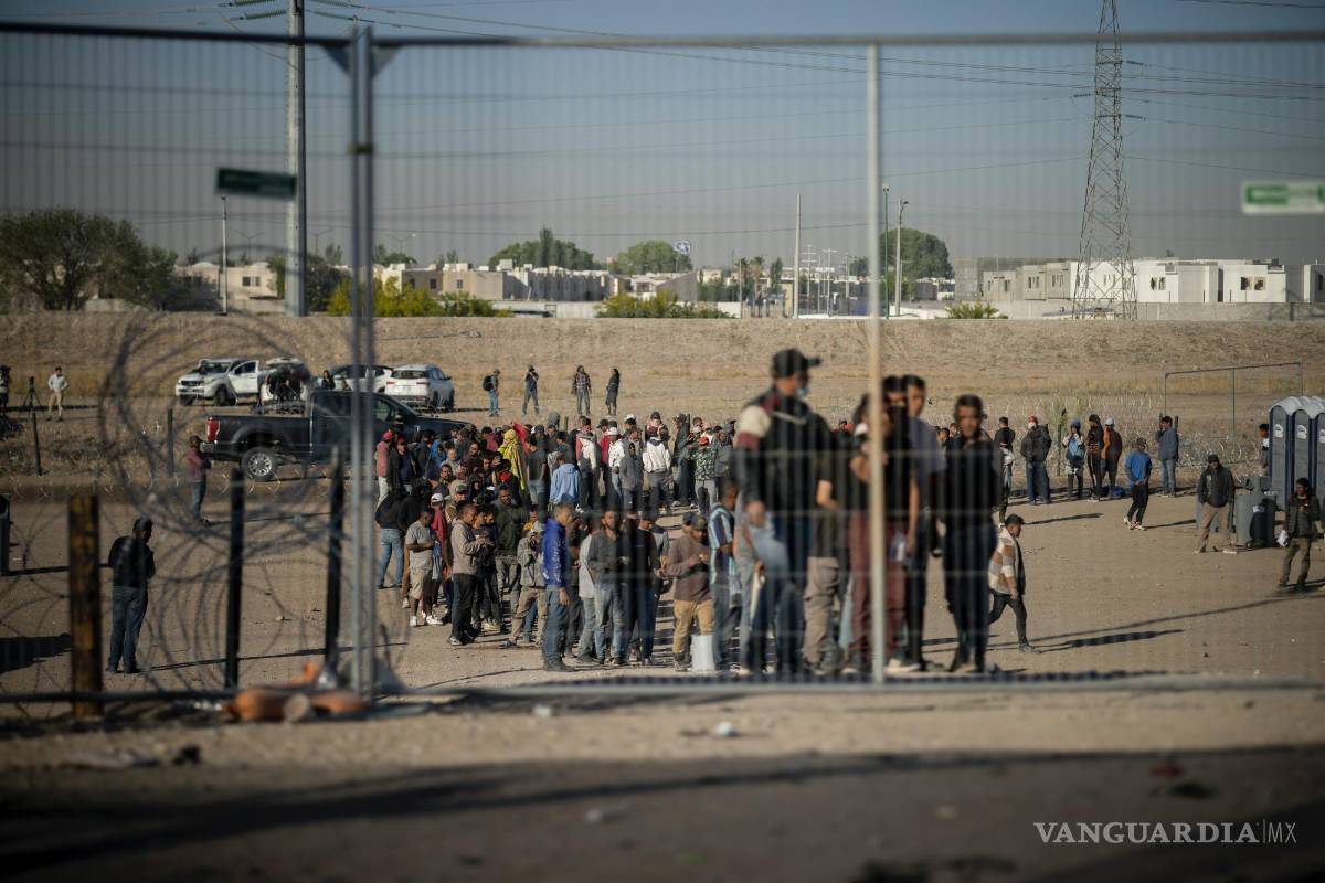 $!Migrantes hacen fila en un campamento de migrantes para ser registrados por agentes de la Patrulla Fronteriza antes de ser procesados en El Paso, Texas.