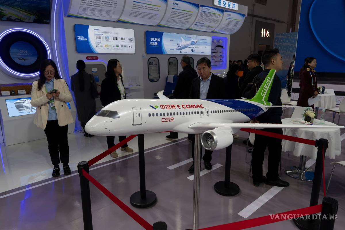 $!Personas frente a un modelo del C919 en el stand de Sinochem durante la Exposición Internacional de la Cadena de Suministro de China en Beijing.
