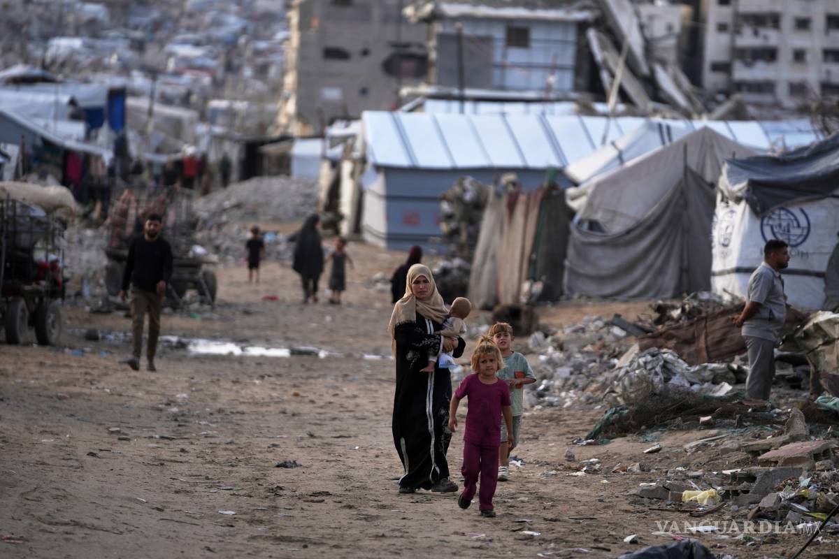 $!Palestinos caminan por un campamento de desplazados en la ciudad de Gaza el domingo 18 de octubre de 2026.