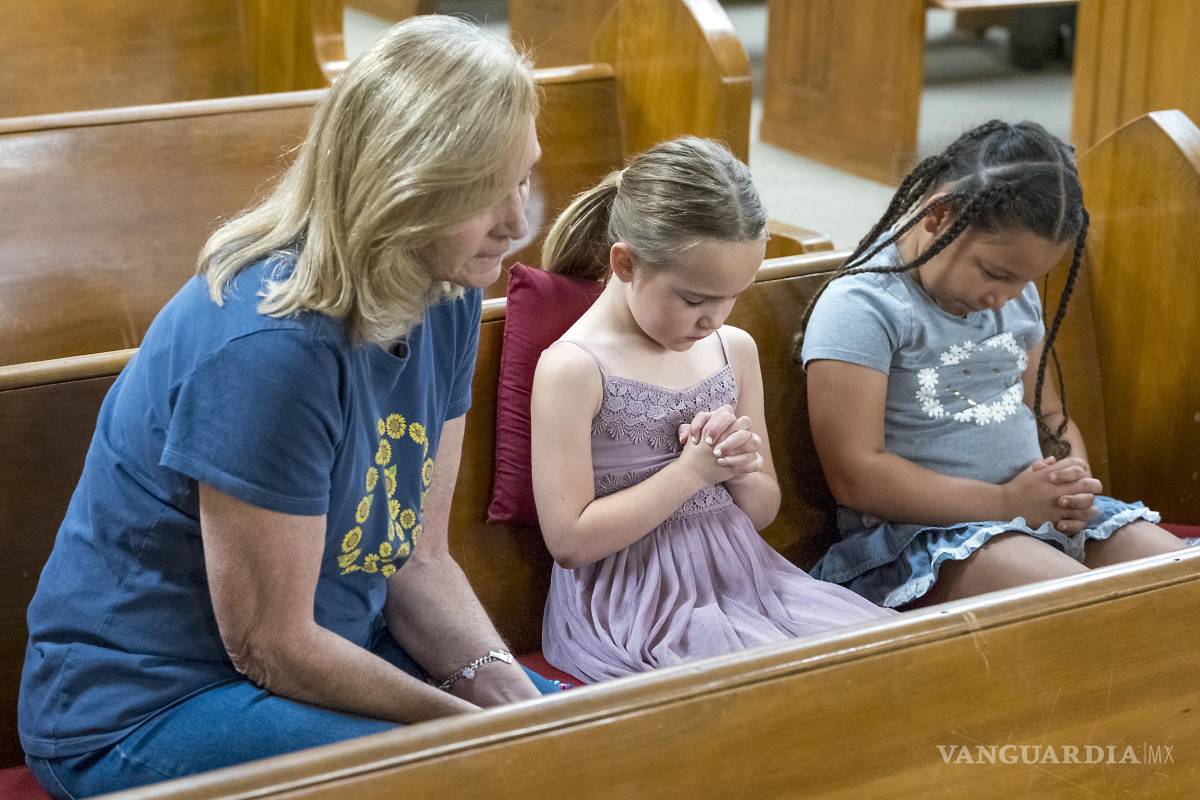 $!Layne Collis se sienta a orar con su nieta, Karsyn Collis (d), y su amiga, Ellie Barrosos, de 7 años (c), en la Iglesia Bautista Hunt en Hunt, Texas.