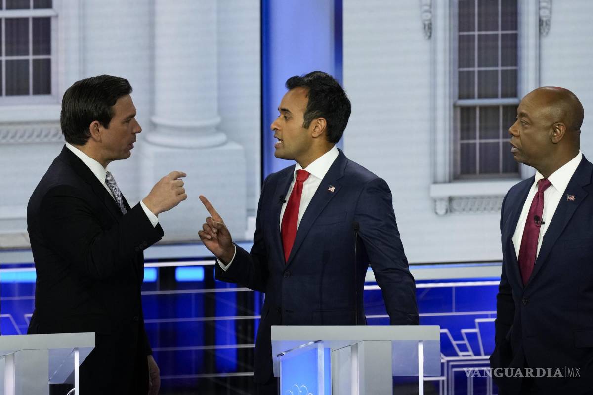 $!El empresario candidato presidencial republicano Vivek Ramaswamy habla con el gobernador de Florida, Ron DeSantis, durante el tercer debate republicano.