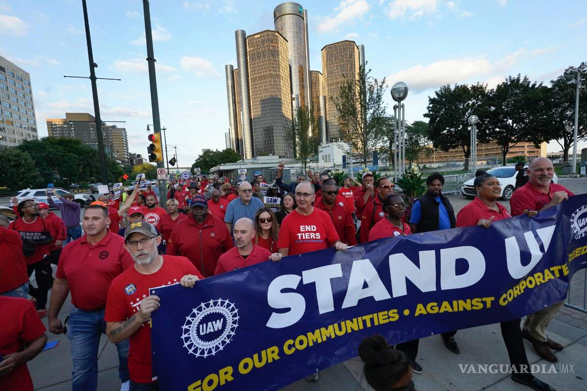 $!Miembros de United Auto Workers, incluido el presidente Shawn Fain (centro), marchan frente a la sede de General Motors en Detroit.