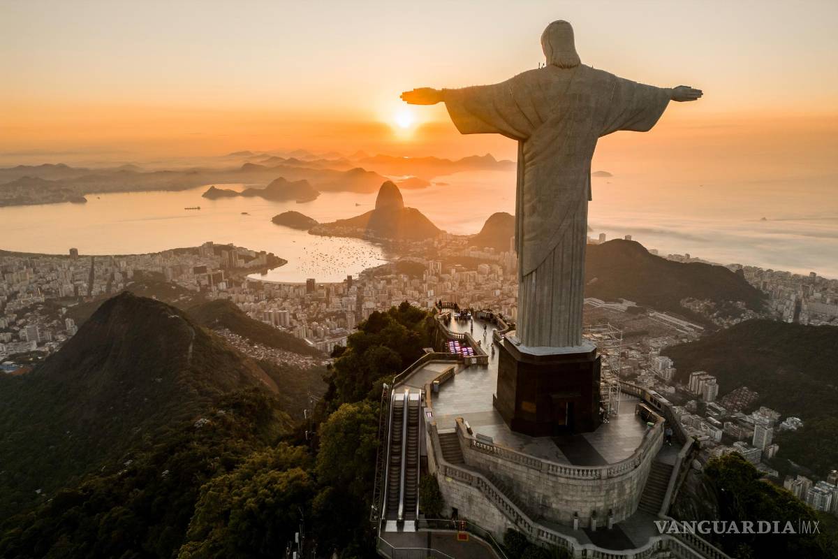 $!Atardecer en el Cristo Redentor del cerro Corcovado (Rio de Janeiro, Brasil), con el cerro Pan de Azúcar al fondo.