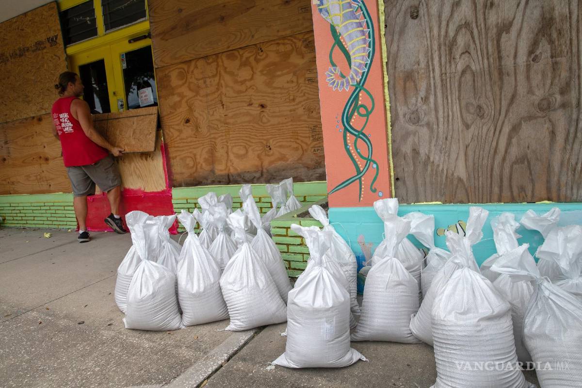 $!Residentes de Gulfport Beach colocan madera contrachapada mientras se preparan para el huracán Ian en Gulfport, Florida.