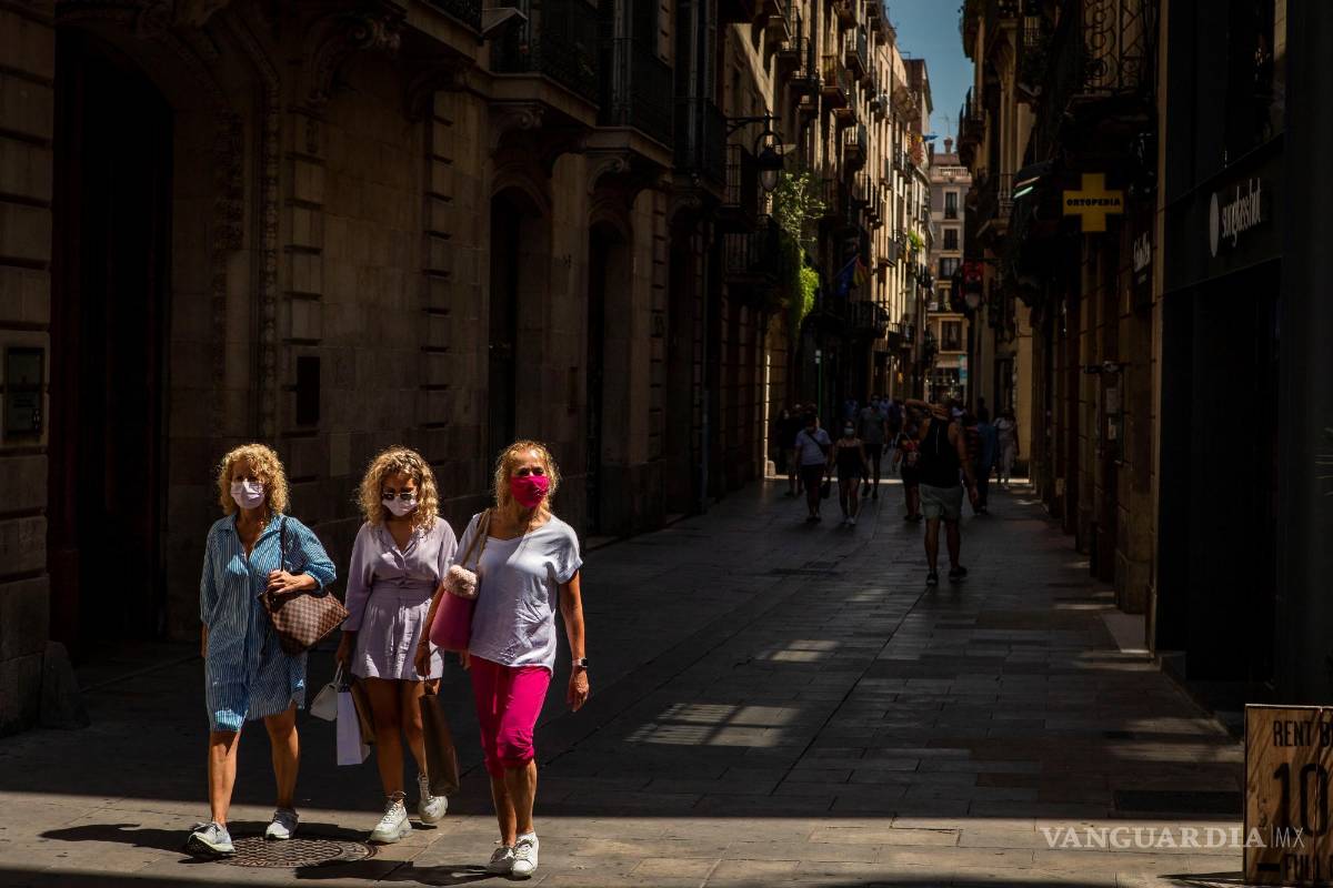 $!Tres visitantes caminan por el barrio gótico de Barcelona.