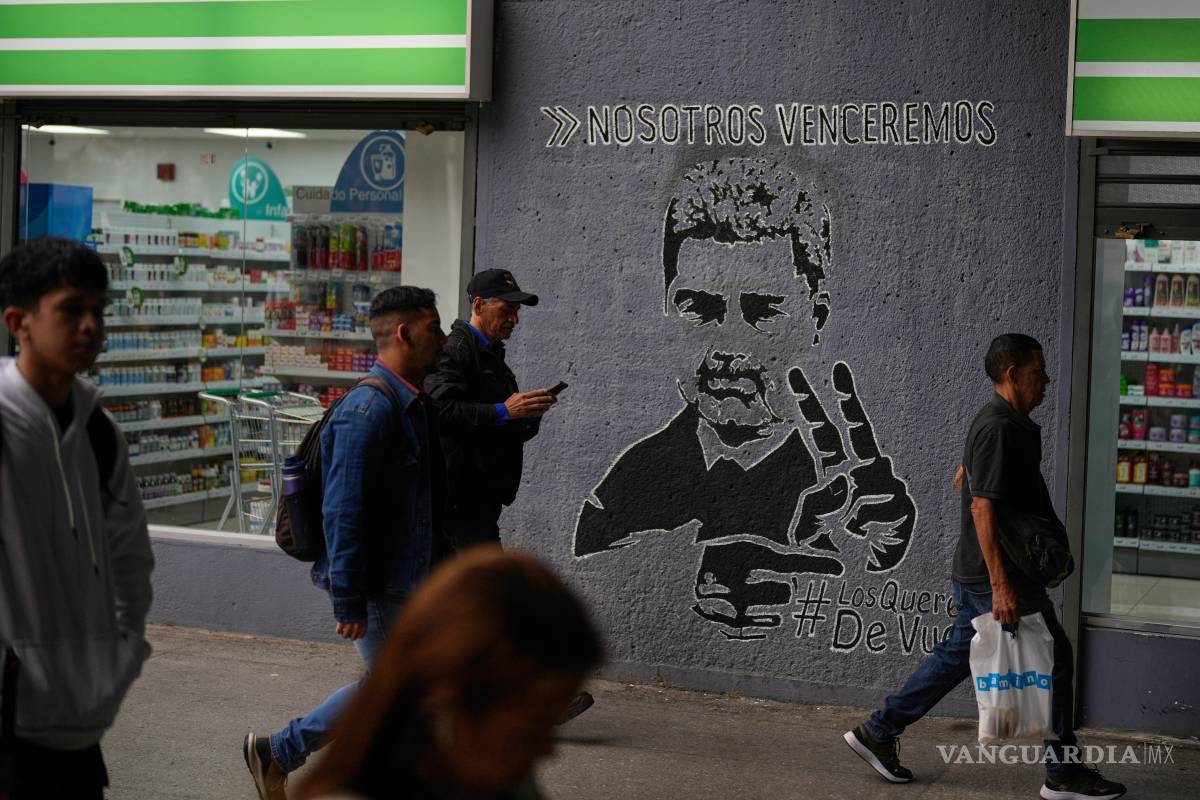 $!Personas pasan junto a un mural del expresidente venezolano Nicolás Maduro con la frase ‘Venceremos’ en Caracas, Venezuela.