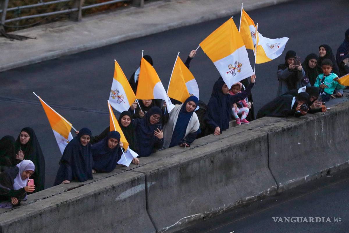 $!Los espectadores ondean banderas del Vaticano mientras observan el paso del convoy que escoltaba al papa León XIV por Beirut, Líbano.
