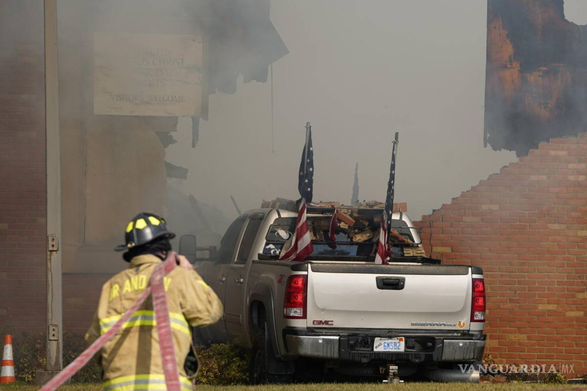 $!Un vehículo embestido contra el edificio está rodeado de humo mientras un bombero trabaja en la Iglesia de Jesucristo de los Santos de los Últimos Días.