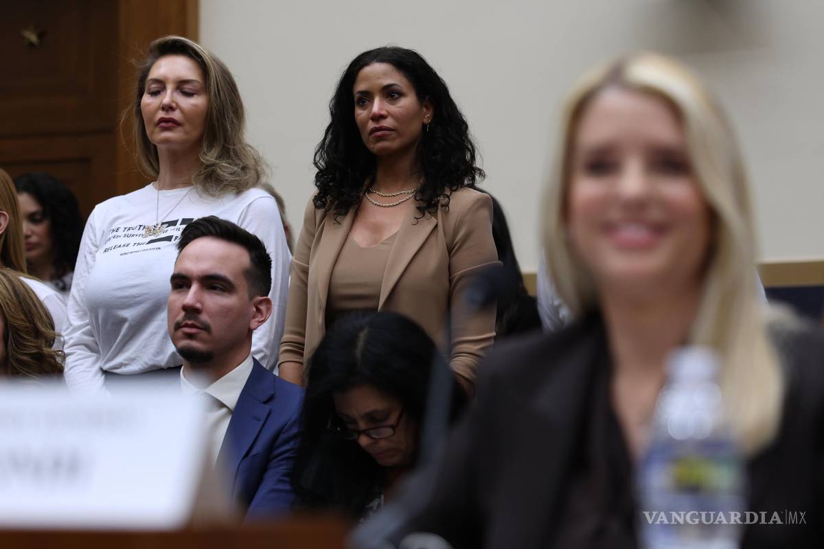 $!La fiscal general Pam Bondi sonríe durante la audiencia en el Capitolio, Washington, mientras sobrevivientes de Jeffrey Epstein, están de pie.