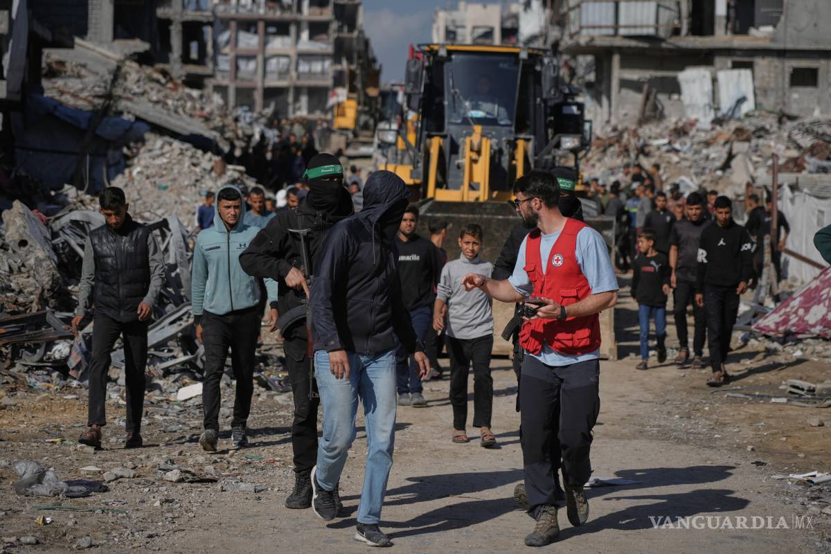 $!Miembros del Comité Internacional de la Cruz Roja observan cómo militantes de Hamás buscan los restos de rehenes en Jabalia, en el norte de la Franja de Gaza.