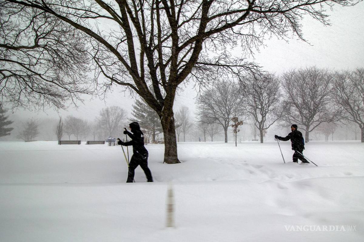 $!Dos personas se desplazan en esquís este domingo, en el centro de Toronto, Canadá.
