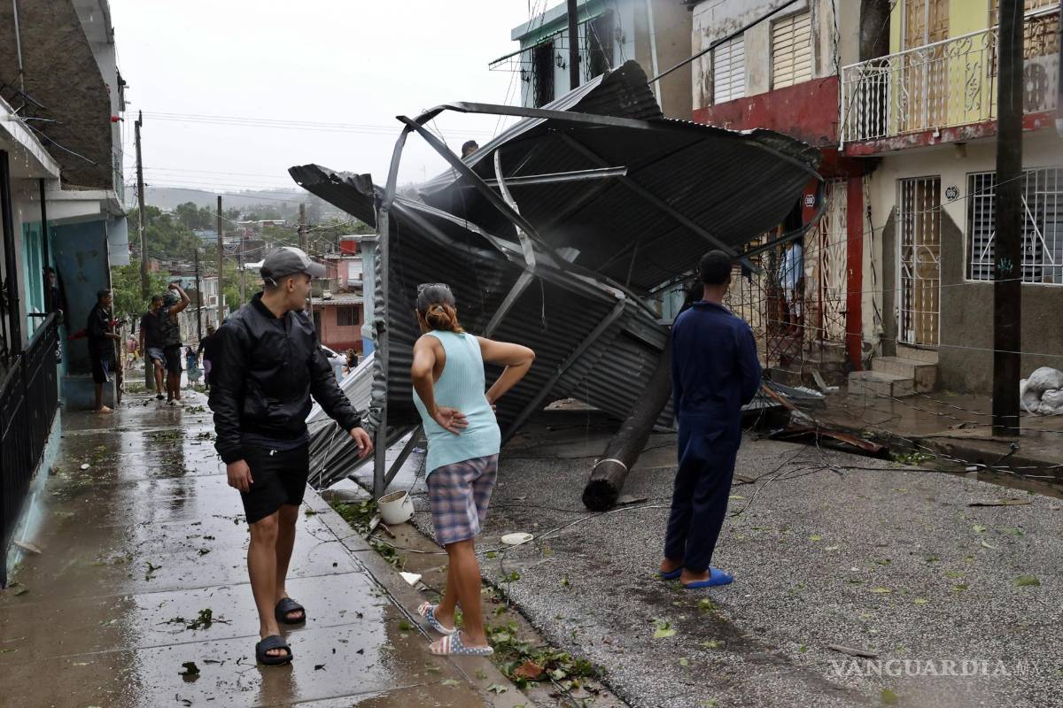 $!Personas caminan por una calle afectada por el paso del huracán Melissa en Santiago de Cuba.