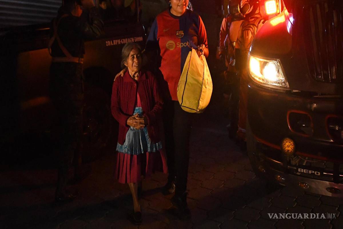 $!ADos mujeres son evacuadas este martes, en Alotenango al suroeste de Ciudad de Guatemala, Guatemala.