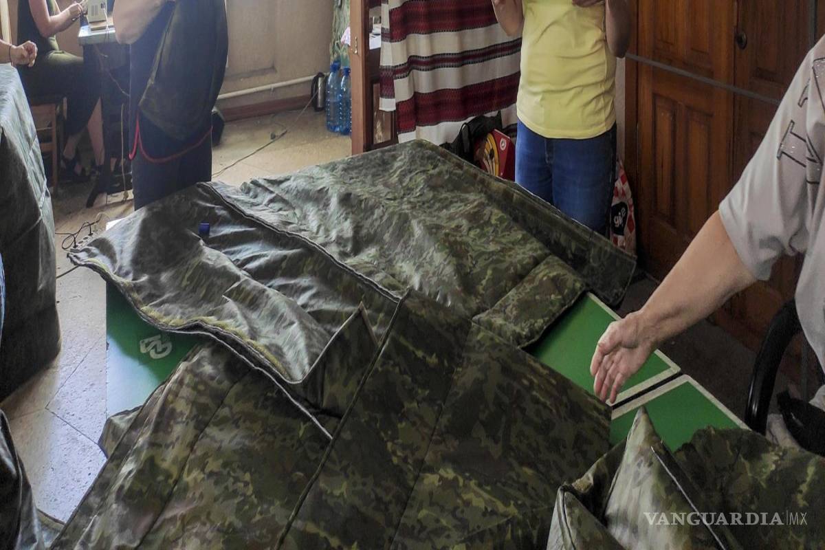 $!Natalia Tkhorzhevska (d), líder del grupo de voluntarios que fabrica ponchos antidrones para soldados ucranianos este lunes, en Kovel, Ucrania.