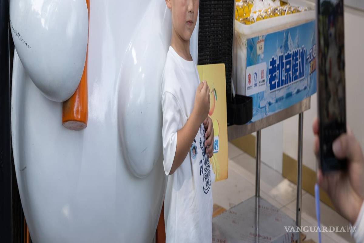 $!Un niño posa para una foto junto a una mascota con forma de oso en una tienda de Beiping Ice Factory, en una zona turística de Pekín, China.