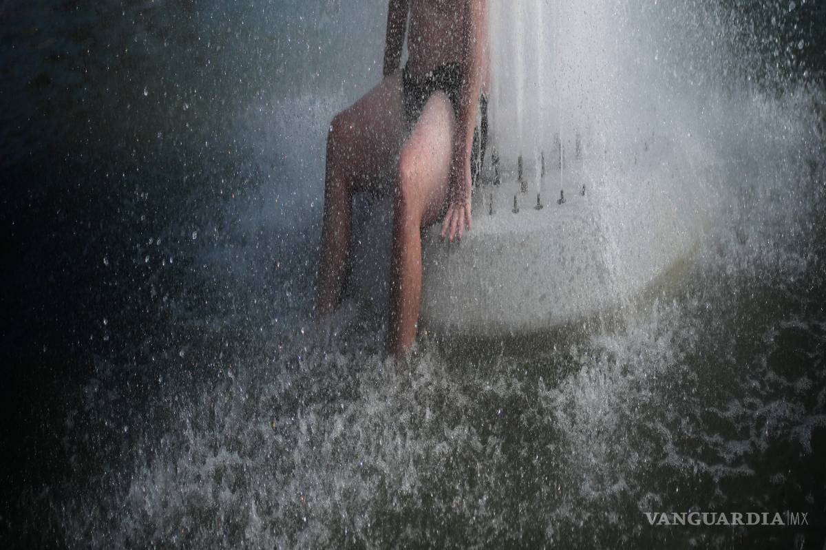 $!Una persona se refresca en una fuente en el Trocadero, cerca de la Torre Eiffel, durante una ola de calor, en París, el 24 de junio de 2026.