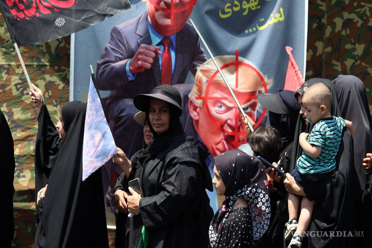 $!Unos iraníes caminan junto a una pancarta contra Trump y Netanyahu durante la ceremonia del día de Arbain en las calles de Teherán, Irán, el 4 de agosto de 2026.