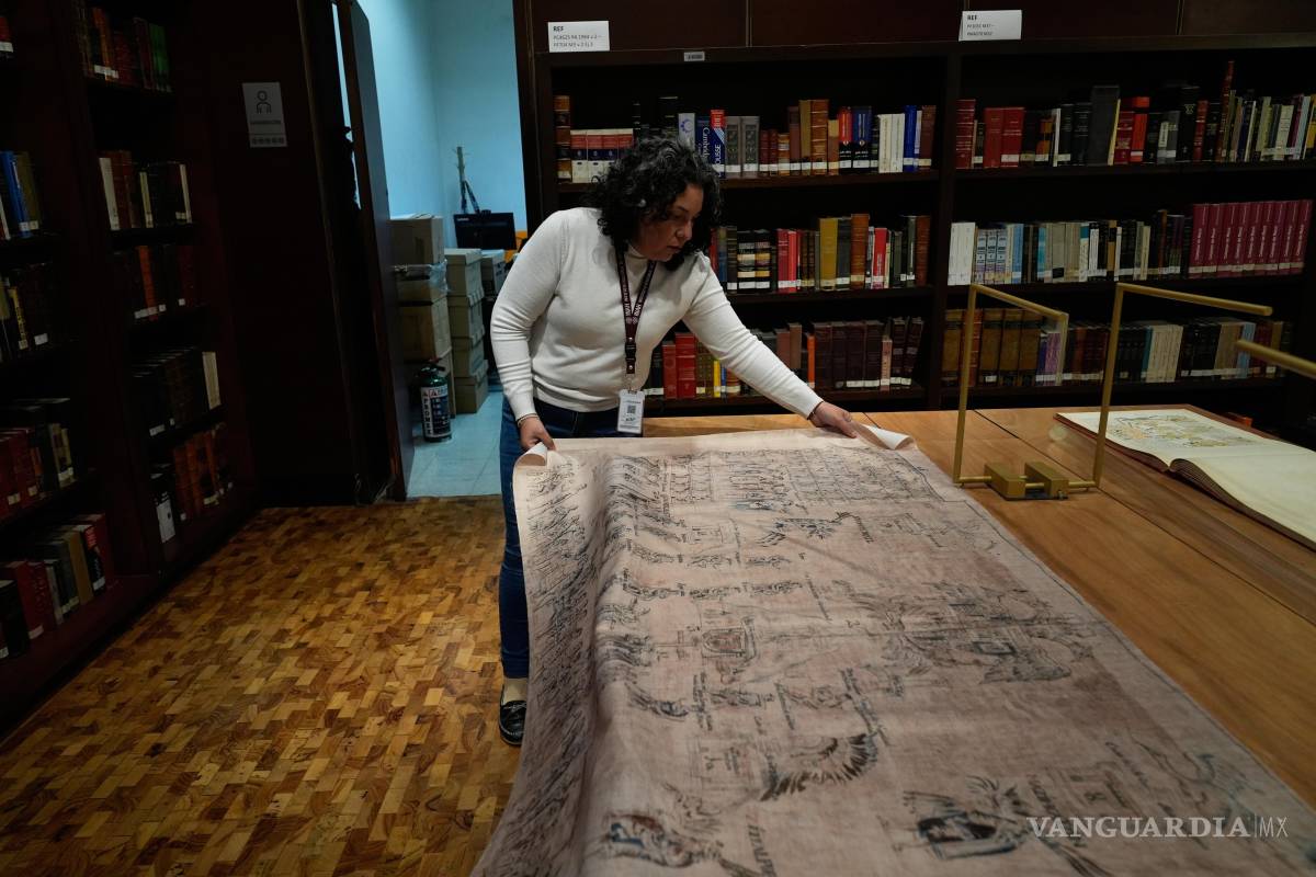 $!Areli Ortiz, subdirectora técnica del INAH, muestra una tela con imágenes de La Malinche y Hernán Cortés de un facsímil de parte del Códice de Tlaxcala.