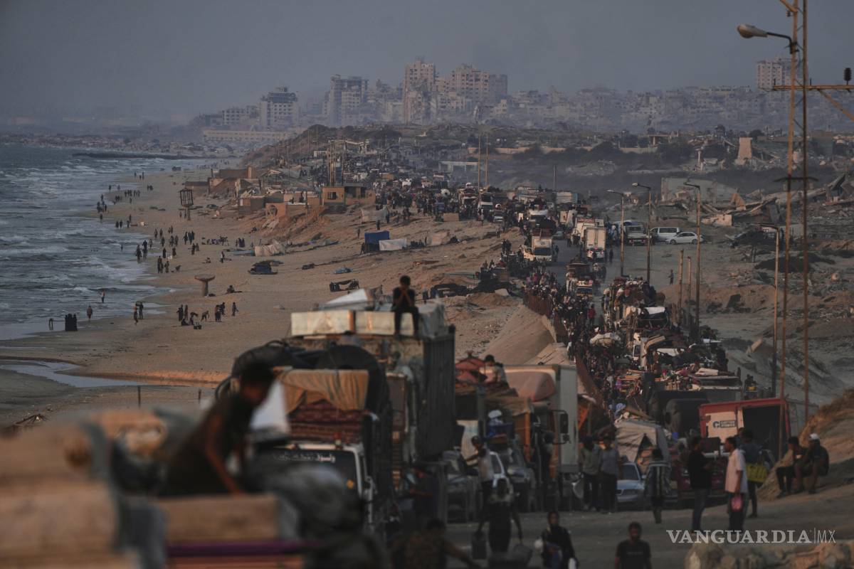 $!Palestinos desplazados huyen de la ciudad de Gaza a pie y en vehículos, cargando con sus pertenencias por la carretera costera hacia el sur.