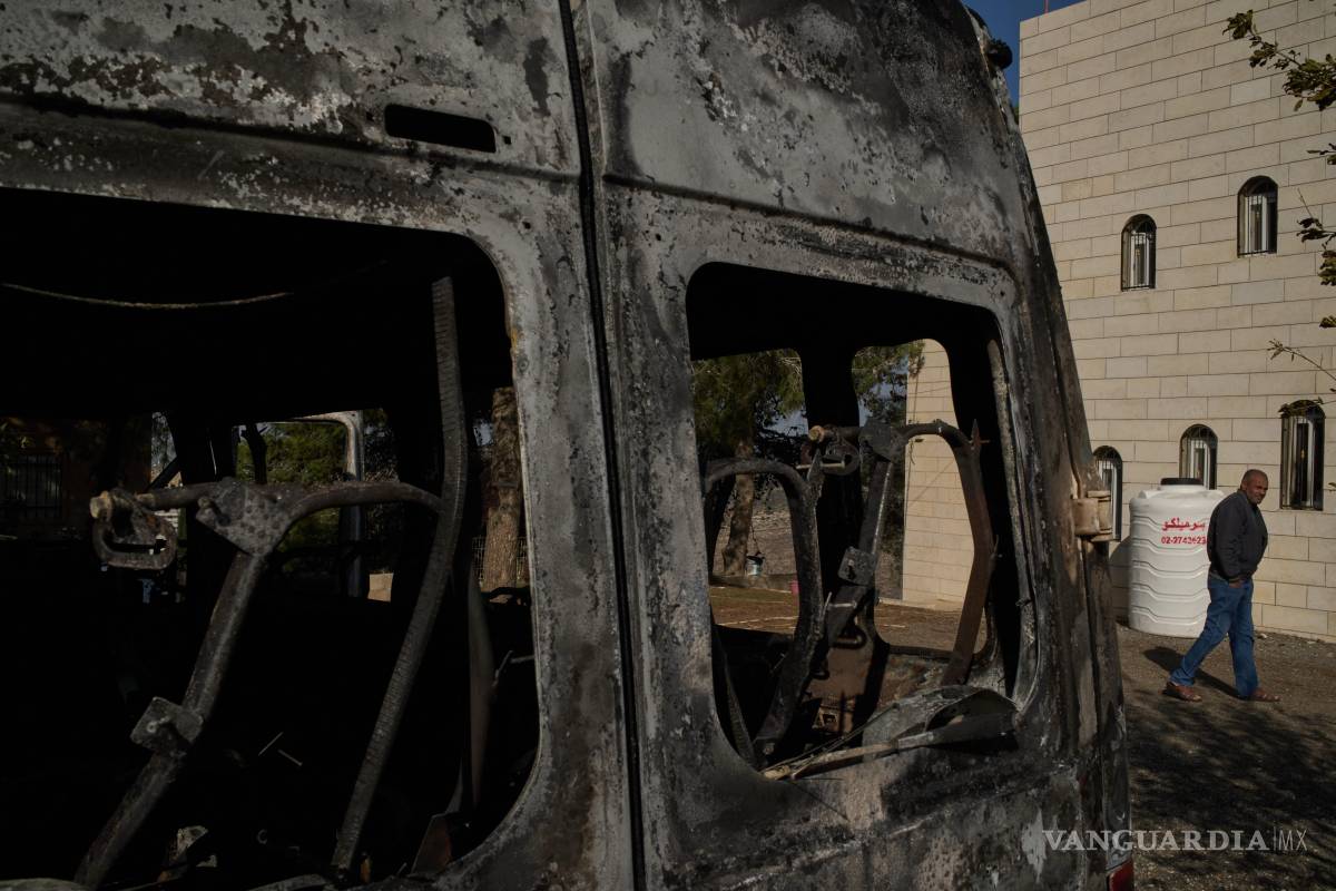 $!Moussab Mshala pasa junto a un vehículo incendiado durante un ataque de colonos israelíes, frente a su casa en la aldea cisjordana de al-Jab’a, cerca de Belén.