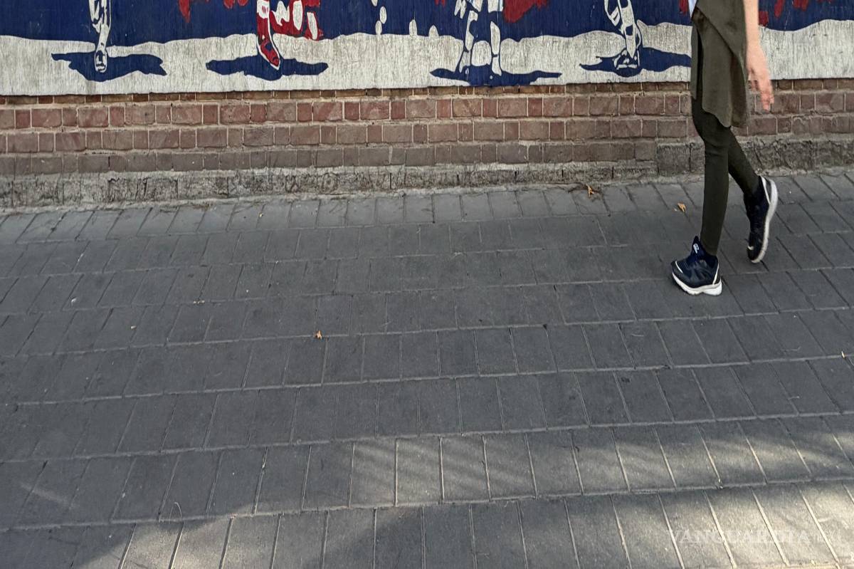 $!Una mujer pasa junto a un mural que representa al centrocampista iraní Hamid Estili anotando un gol contra EU en la Copa Mundia de 1998, que Irán ganó 2-1.