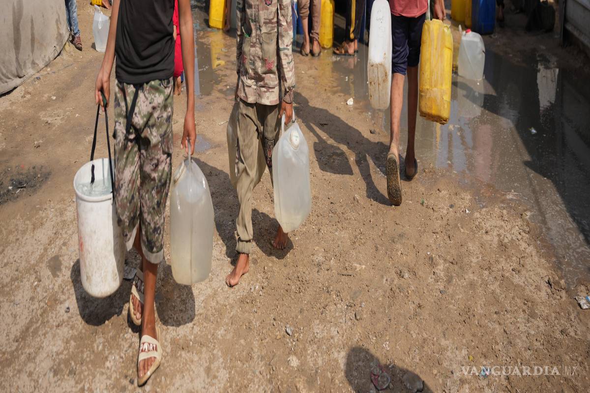 $!Palestinos desplazados se reúnen para recoger agua de un camión en un campamento de tiendas de campaña improvisado en Khan Younis, Franja de Gaza.