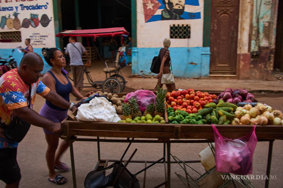 $!Vendedores ambulantes empujan su carrito de verduras junto a un mural de Fidel Castro en La Habana, Cuba, el miércoles 12 de agosto de 2026.