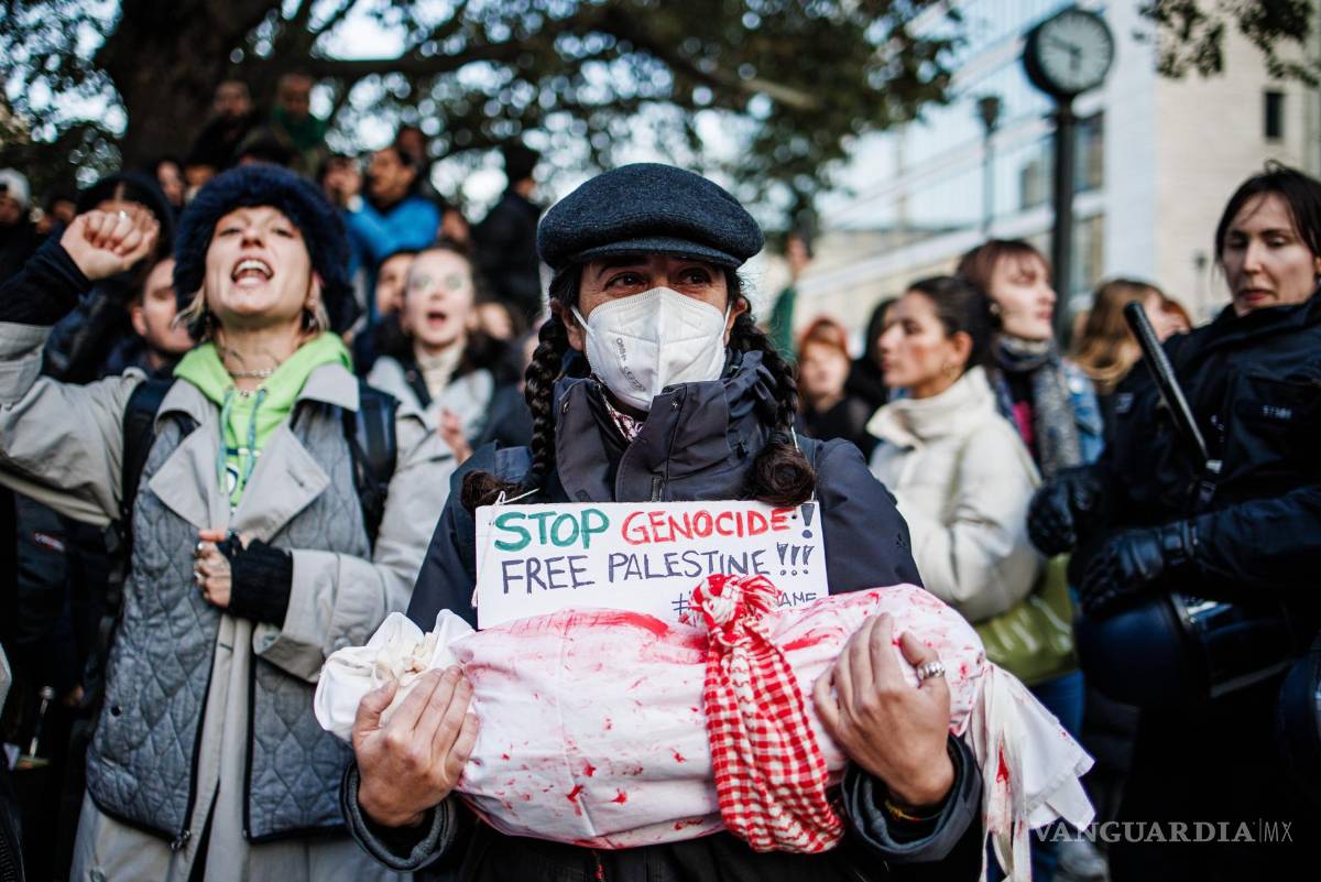 $!Un activista sostiene un objeto vestido con una tela blanca coloreada con pintura roja y un cartel que dice “Alto al genocidio - Palestina libre” en Berlín, Alemania.