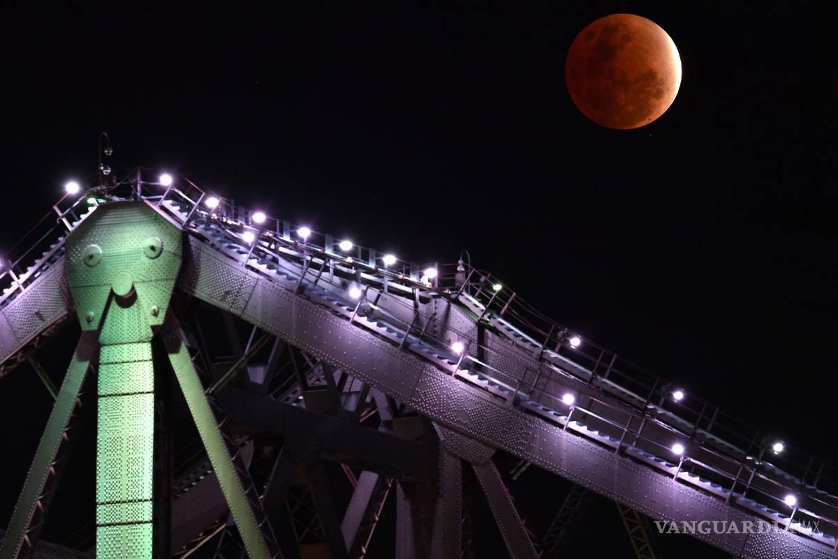 $!La luna se alza sobre el puente Story de Brisbane (Australia) con parte de su superficie cubierta con la sombra de la tierra durante un eclipse lunar parcial. EFE/Darren England