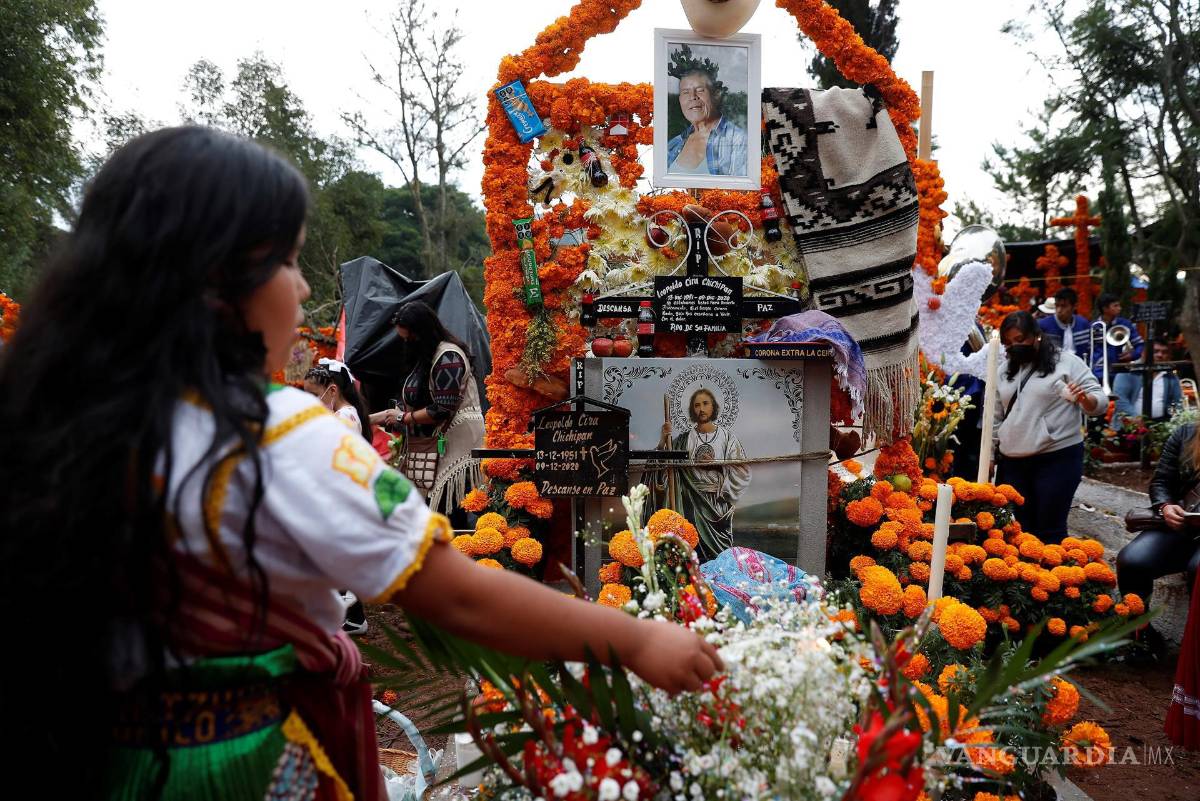 $!Familiares acuden a poner ofrendas y arreglar tumbas en el panteón municipal de Tzintzuntzan, en el estado de Michoacán, México. EFE/Alex Cruz