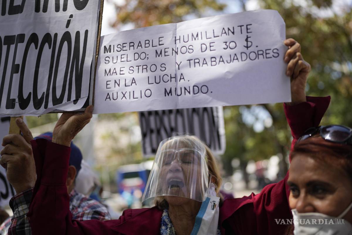 $!Una mujer sostiene un cartel durante una protesta en reclamo de un aumento en las pensiones en medio de una inflación récord mundial en Caracas, Venezuela, el 15 de febrero de 2022.