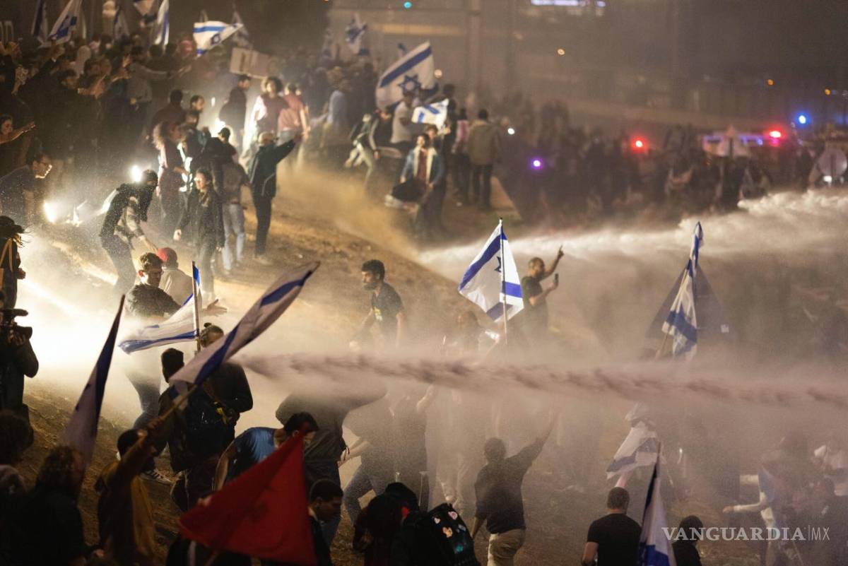$!Policías israelíes emplean un cañón de agua para dispersar a los manifestantes que cortan una autopista en Tel Aviv, Israel.