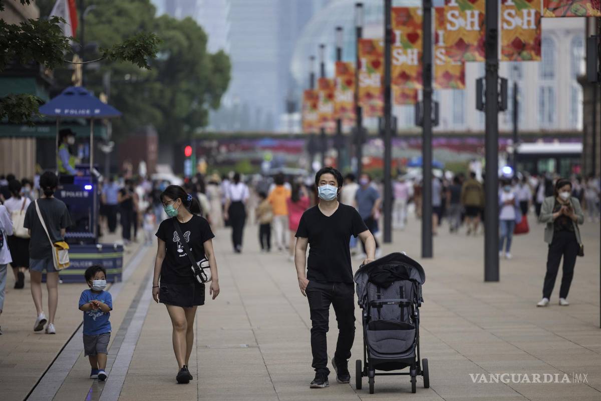 $!La gente camina por la calle Nanjing, una de las principales zonas comerciales, en el primer día de relajación de las restricciones por el COVID-19, en Shanghái, China.