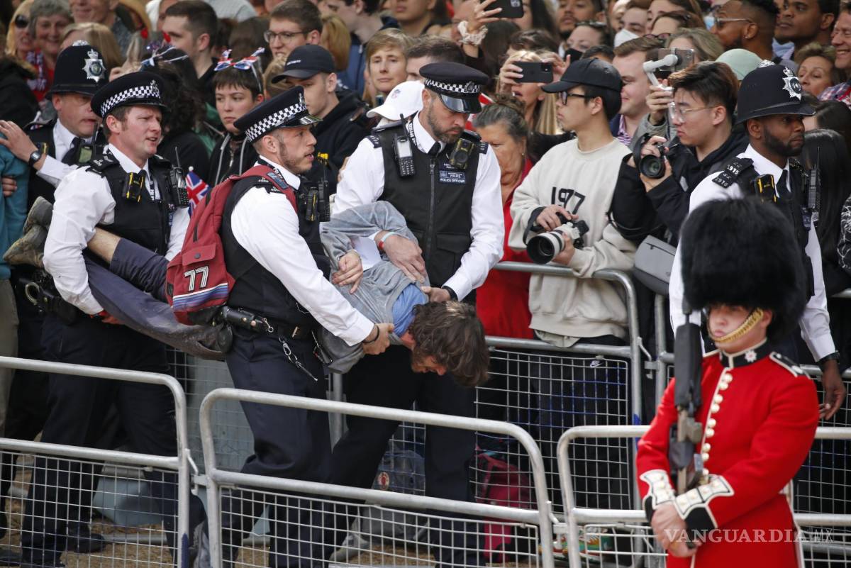 $!Policías retiran a un hombre que corrió en la ruta de la procesión real en el paseo The Mall en Londres antes del Desfile del Estandarte.