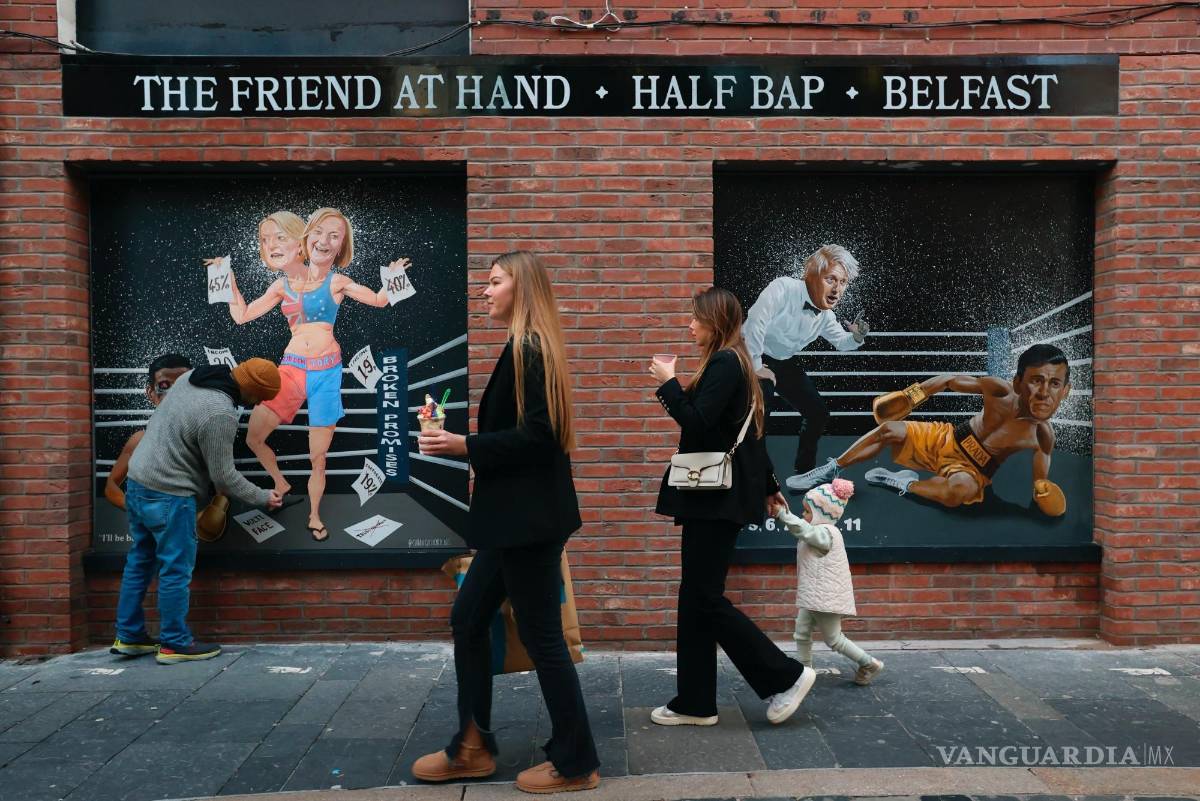 $!La gente pasa frente a un mural del artista Ciaran Gallagher que refleja los problemas políticos de la primera ministra británica, Liz Truss, en Belfast.
